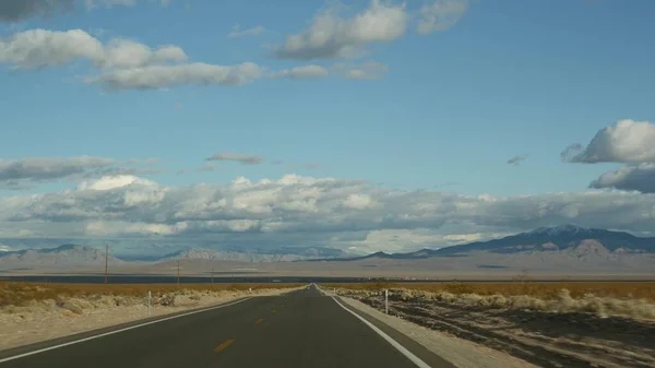 Road trip, auto rijden van Death Valley naar Las Vegas, Nevada USA. Liften op reis in Amerika. Highway reis, dramatische sfeer, wolk, berg en Mojave woestijn wildernis. Zicht vanuit auto — Stockfoto