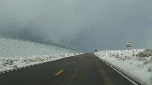 Viagem de carro para Death Valley, dirigindo automóvel, neve na Califórnia, EUA. A apanhar boleia no Inverno, a viajar pela América. Estrada, passagem de montanha e deserto árido e árido. Passageiro POV do carro. Viagem para Nevada — Fotografia de Stock