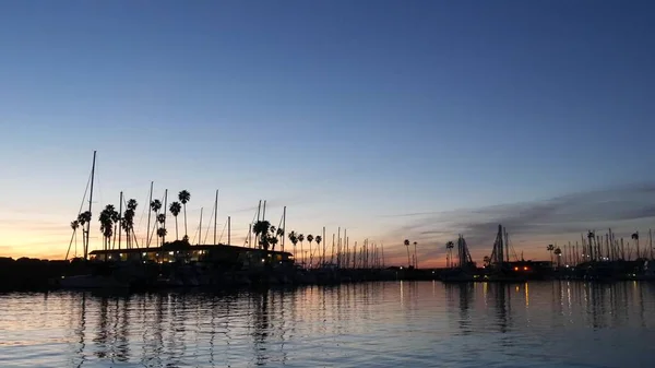 Yachts sailboats in marina harbour. Sail boat masts in twilight. Dusk in harbor, California USA. — Stock Photo, Image