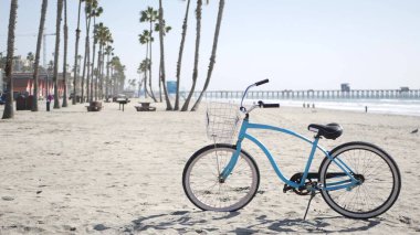 Okyanus kıyısında bisiklet kruvazörü bisikleti, Kaliforniya kıyısı ABD. Yaz döngüsü, cankurtaran kulübesi ve palmiye ağacı