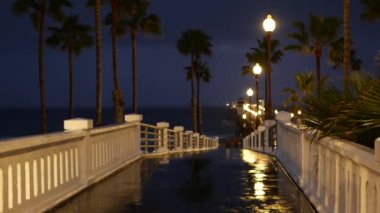 Yağmur damlaları, Oceanside California USA 'da akşam. İskele, alacakaranlıkta avuçlar. Işığın yansıması.