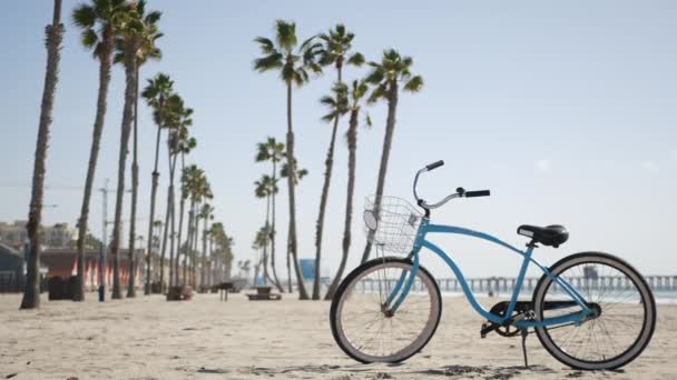 Bicycle cruiser bike by ocean beach, California coast USA. Summer cycle, lifeguard hut and palm tree — Stock Video