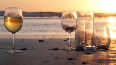 Camdaki mum ışıkları, okyanus dalgalarıyla romantik plaj tarihleri, yaz denizi. Kumdaki mum ışığı..