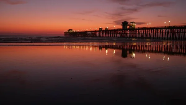 Pier silhouette Oceanside California USA. Ocean tide tropical beach. Summertime gloaming atmosphere. — Stock Photo, Image