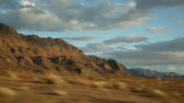 Road trip, driving auto from Death Valley to Las Vegas, Nevada USA. Hitchhiking traveling in America. Highway journey, dramatic atmosphere, sunset mountain and Mojave desert wilderness. View from car — Stock Video