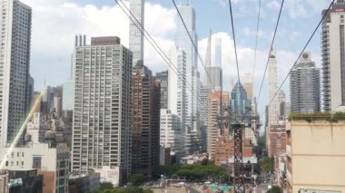 New York, ABD - 4 Eylül 2023: Manhattan Midtown sokaklarına giden Roosevelt Adası tramvayı. Amerikan tramvayı, Queensboro Köprüsü. Kentsel toplu taşıma, ABD. Mimari şehir manzarası inşa ediliyor.