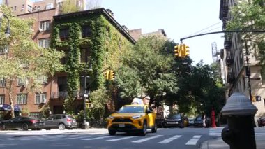 New York City, ABD, 6 Eylül 2023 Manhattan şehir merkezi Irving sokak köşesi, kavşak, Gramercy, ABD. İnsanlar yayalar. Sarı taksi. Sarmaşık yapraklarıyla kaplı kırmızı tuğladan ev