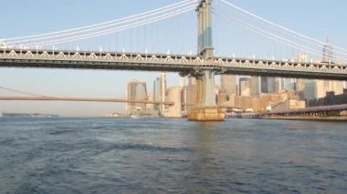 New York, Birleşik Devletler - 7 Eylül 2023: Manhattan Köprüsü 'nden Brooklyn' e. Şehir merkezindeki liman kenti, 35 numaralı rıhtımdan finansal bölge gökdelenleri. Doğu Nehri Sabah Günbatımı.