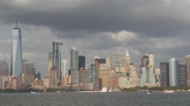 New York City Manhattan şehir merkezi feribottan Özgürlük Adası 'na, Amerika Birleşik Devletleri' ne ufuk çizgisi. Finans Bölgesi şehir manzarası, Dünya Ticaret Merkezi gökdelen kulesi. Şehir binaları mimarisi. Yağmur bulutları.