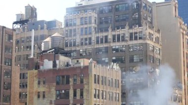 New York City şehir merkezi yerleşim binası, kırmızı kahverengi tuğla mimari, Manhattan çatısı, Amerika Birleşik Devletleri. Çatıda su kulesi, su tankları. Hells Kitchen Liman İdaresi. Sıcak buhar.