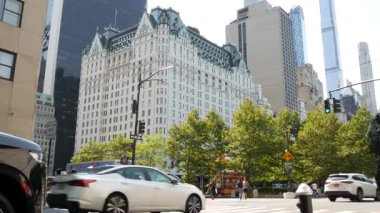 New York, ABD - 5 Eylül 2024: 5. Cadde, Manhattan Midtown Caddesi. Plaza Otel binası, Central Park yakınlarındaki Grand Army Plaza. Kavşaktaki yayalar, yoldaki sarı taksi...