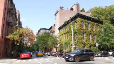 New York, Amerika Birleşik Devletleri - 5 Eylül 2024: Manhattan West Village Greenwich caddesi köşesindeki apartman mimarisi. Greenwich Köyü kavşağı. Tuğla ev, duvarda yeşillik. Sarı taksi..
