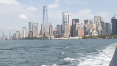 New York City Manhattan şehir merkezi feribottan Özgürlük Adası 'na, Amerika Birleşik Devletleri' ne ufuk çizgisi. Finans Bölgesi şehir manzarası, Dünya Ticaret Merkezi gökdelen kulesi. Liman kenti mimarisi.