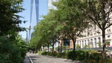 New York City, ABD - 6 Eylül 2024: Lower Manhattan Downtown Financial District. Dünya Ticaret Merkezi gökdelen binası, Battery Park 'tan Özgürlük Kulesi. Batı caddesi bisiklet yolu, bisikletçi..