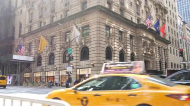 New York, Amerika Birleşik Devletleri - 5 Eylül 2024: Beşinci Cadde, Central Park yakınlarındaki Manhattan Midtown alışveriş caddesi. Peninsula Oteli yakınlarında yayalar var. Sarı taksi yolda..