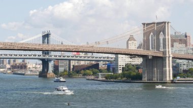 Brooklyn Köprüsü ve Manhattan Köprüsü, Downtown, New York City, ABD 'den. ABD 'deki Esplanade iskelesi parkı. Amerikan mimarisi, ünlü turistik mekan. Rıhtım kenti gezisi. Sudaki tekne..