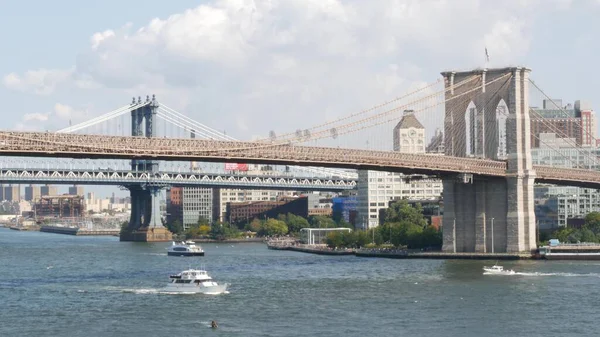 Brooklyn Köprüsü ve Manhattan Köprüsü, Downtown, New York City, ABD 'den. ABD 'deki Esplanade iskelesi parkı. Amerikan mimarisi, ünlü turistik mekan. Rıhtım kenti gezisi. Sudaki tekne..