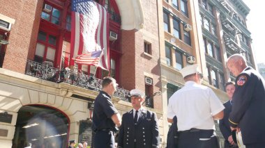 New York City, ABD - 11 Eylül 2024: İtfaiyeciler anma töreninde, itfaiyeciler istasyonunda. İtfaiye Memurları, Araç 33, Ekip 9. Vatanseverlik Günü. Kırmızı tuğla tarihi bina mimarisi