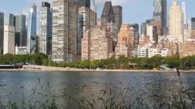 Amerika Birleşik Devletleri Roosevelt Adası 'ndan New York City Manhattan şehir merkezi silueti. Kırmızı tuğla binalar, nehir kenarı manzarası East River suyu, Turtle Bay evleri, gayrimenkul..