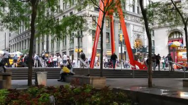 New York, ABD - 17 Eylül 2024 Broadway, Manhattan Merkez Finans Bölgesi. Liberty caddesindeki Zuccotti Park Ağaçları. Hayatın neşesi kırmızı sanat heykeli ve insanlar. Arabalar yolda, NYC Fidi