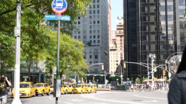 New York, ABD - 15 Eylül 2024 Manhattan şehir merkezi Columbus Circle Broadway Caddesi. Sarı taksi arabası. İnsanlar yaya, halka açık otobüs durağı tabelası. Küre Heykeli, Sanat Anıtı. Batı Yakası.