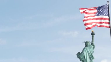 Özgürlük Heykeli Özgürlük Adası, New York, ABD 'de. Arkadan Cooper anıtı, New York, Manhattan yakınlarında demokrasi ve vatanseverlik sembolü. Rüzgarda dalgalanan Amerikan bayrağı. Bağımsızlık kavramı.