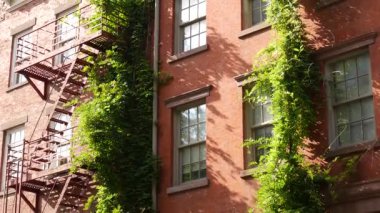 New York City şehir binaları mimarisi, Manhattan klasik caddesi, Amerika Birleşik Devletleri. New York 'taki tipik kırmızı tuğlalı ev, ABD' deki emlak mülkü. Yangın çıkışı metalik merdiven.