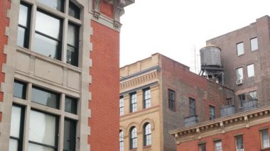 New York şehrinin kırmızı tuğla bina mimarisi, Aşağı Manhattan çatısı, Amerika Birleşik Devletleri. Çatıdaki su kulesi. Şehir merkezinde klasik su tankları. Tribeca 'daki Varick Caddesi. İtfaiye