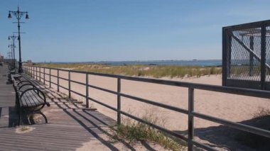 Brooklyn, New York, ABD 'deki Coney Adası plaj gezisi. Retro Ay Parkı 'nın yakınındaki tahta tahta kaldırım. Okyanus kıyısındaki banklar, kumlu sahil. NYC, ABD 'de liman tatili. Açık hava eğlencesi