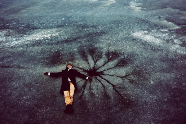Man laying on ice in winter — Stock Photo, Image