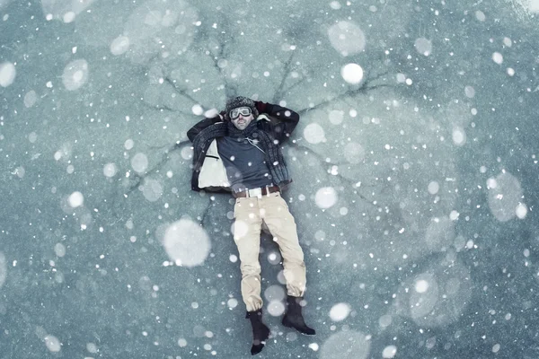 Homem deitado no gelo no inverno — Fotografia de Stock