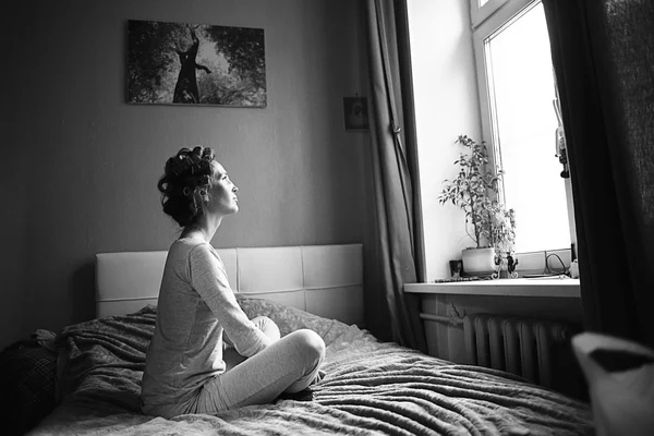 Pretty housewife sitting on bed — Stock Photo, Image