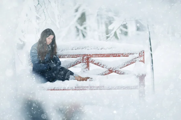 Jeune fille assise sur le banc — Photo