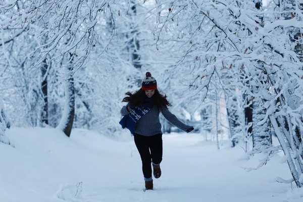 雪の降る公園で走っている少女 — ストック写真