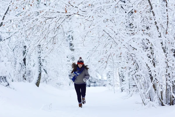 雪の降る公園で走っている少女 — ストック写真