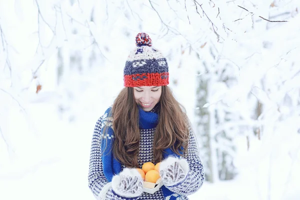 Mädchen mit Mandarinen im Winter — Stockfoto