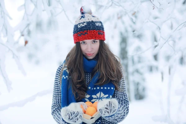 Meisje met mandarijnen in de winter — Stockfoto