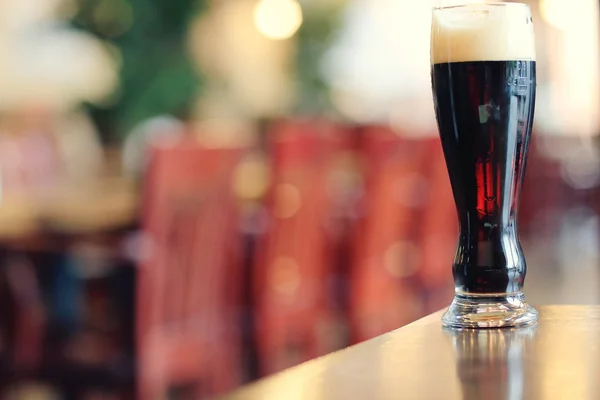Glas donker bier op tafel — Stockfoto