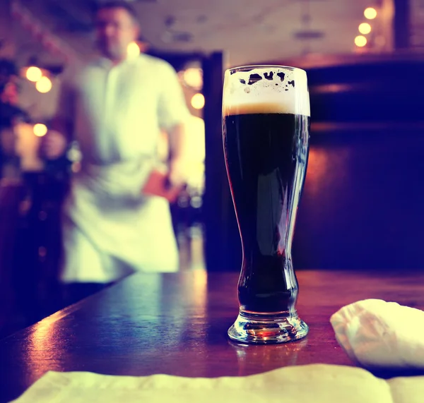 Glas donker bier op tafel — Stockfoto