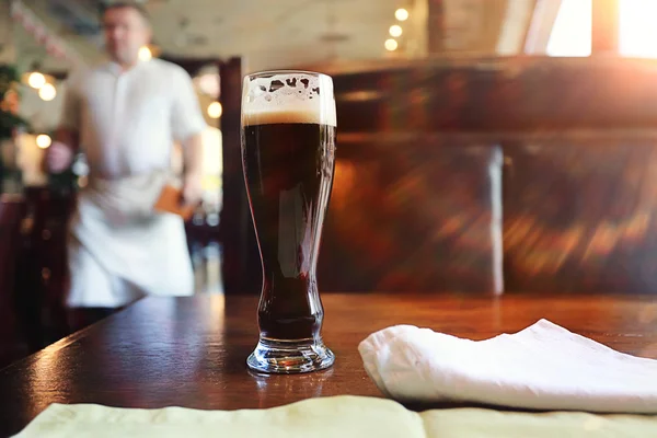 Склянка темного пива на столі — стокове фото