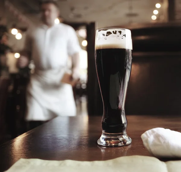 Glas donker bier op tafel — Stockfoto