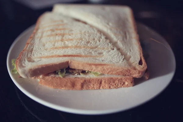 Lahodný sendvič na bílé desce — Stock fotografie