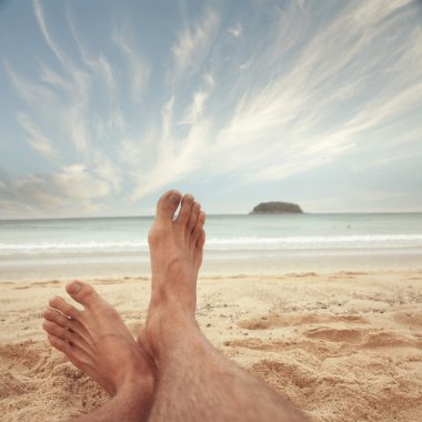 Kum plajındaki insan ayakları