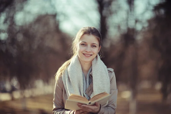 Mädchen in Mantel und mit Buch — Stockfoto