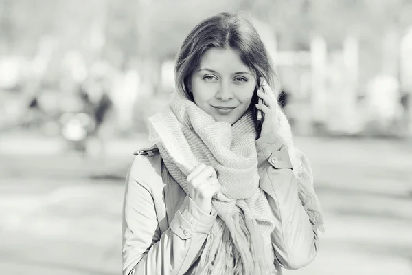 Meisje in een jas in de stad — Stockfoto