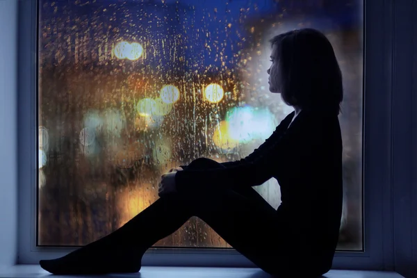 Girl sitting near window — Stock Photo, Image