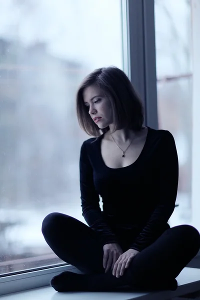 Girl sitting near window — Stock Photo, Image