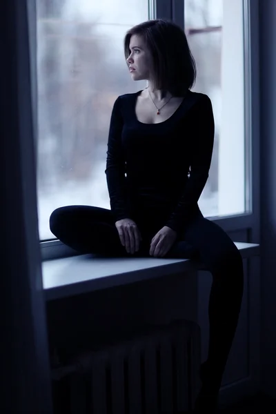 Girl sitting near window — Stock Photo, Image