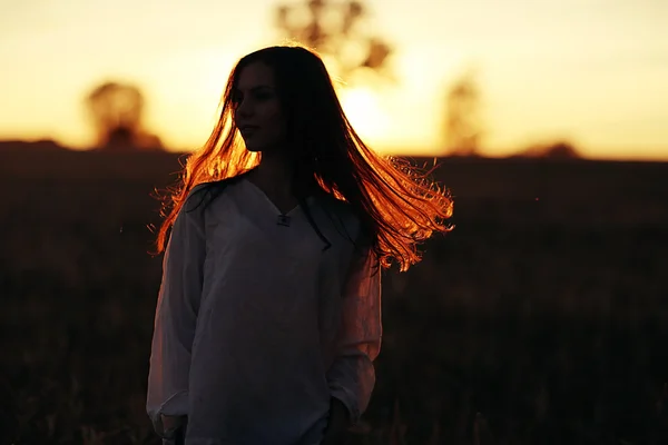 Menina com cabelo comprido ao pôr do sol — Fotografia de Stock