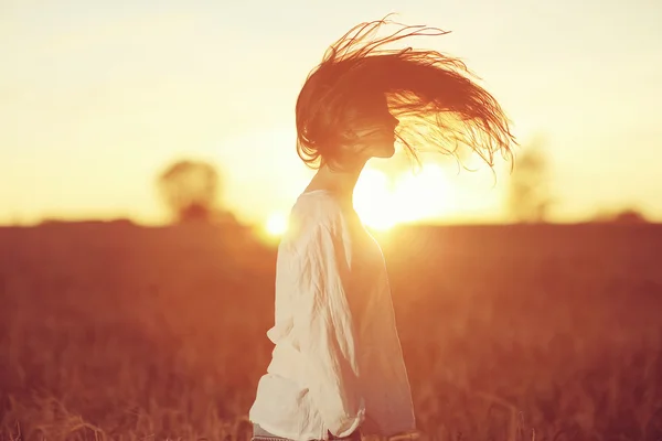 Flicka med långt hår i solnedgången — Stockfoto